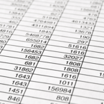 An angled, close-up view of a printed spreadsheet document filled with rows and columns of numerical data.