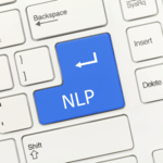 A close-up view of a computer keyboard featuring a prominent blue Enter key printed with the abbreviation "NLP".