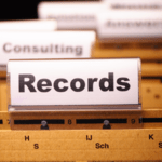 A close-up view of hanging manila file folders in a filing cabinet with a prominent clear plastic tab labeled "Records".